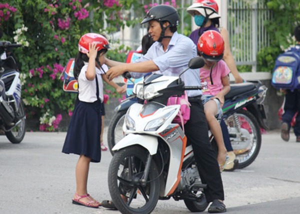 Hình ảnh an toàn giao thông đẹp - Bố mẹ tập cho trẻ đội mũ bảo hiểm từ sớm để đảm bảo an toàn